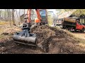 Hammering a drainage trench behind a house