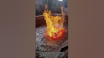 Hot metal parts being quenched in liquid for hardening