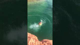 Woman jumps from top of cliff into water