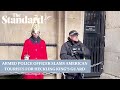 Armed police officer confronts american tourists for heckling member of kings guard
