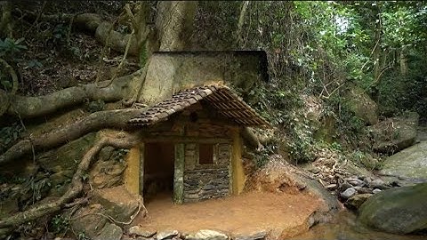 Xây dựng một nơi trú ẩn bằng đá và gỗ dưới gốc cây cổ thụ để sinh tồn trong rừng rậm