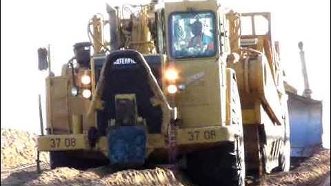 Short clip of a 637E being push loaded full of sand by a D8R