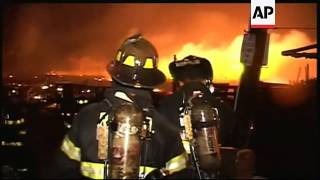 Firefighters battling to control blaze that has destroyed dozens of flooded homes
