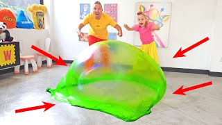 Alicia le está enseñando a papá cómo hacer burbuja de Slime gigante para niños en casa