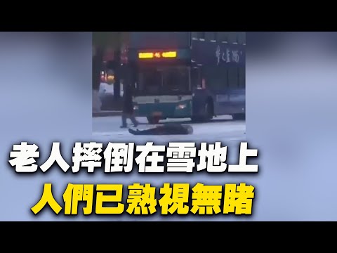 东北某地，一位老人摔倒后躺在冰天雪地的马路上，来往的人们已熟视无睹。