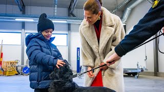 Princess Estelle and Prince Oscar cuddeling with a dog at the Swedish Customs office