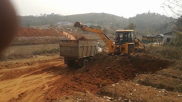 Jcb digging and loading soil in a dump truck