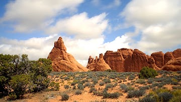 Time-lapse of clouds moving over a desert landscape.