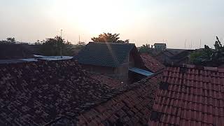 Footage video pemandangan matahari pagi dari atap rumah - genting