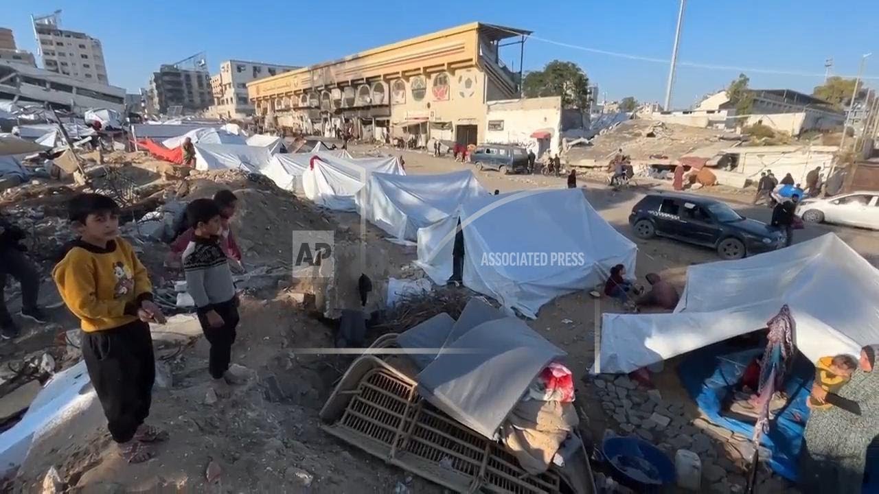 Displaced residents relocate to Gaza City and live in tents among piles of rubbish and rubble