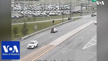 A driver was caught on camera reversing on a busy US highway, narrowly missing other vehicles.