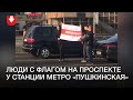 Двое с флагом идут по проспекту у станции метро «Пушкинская»