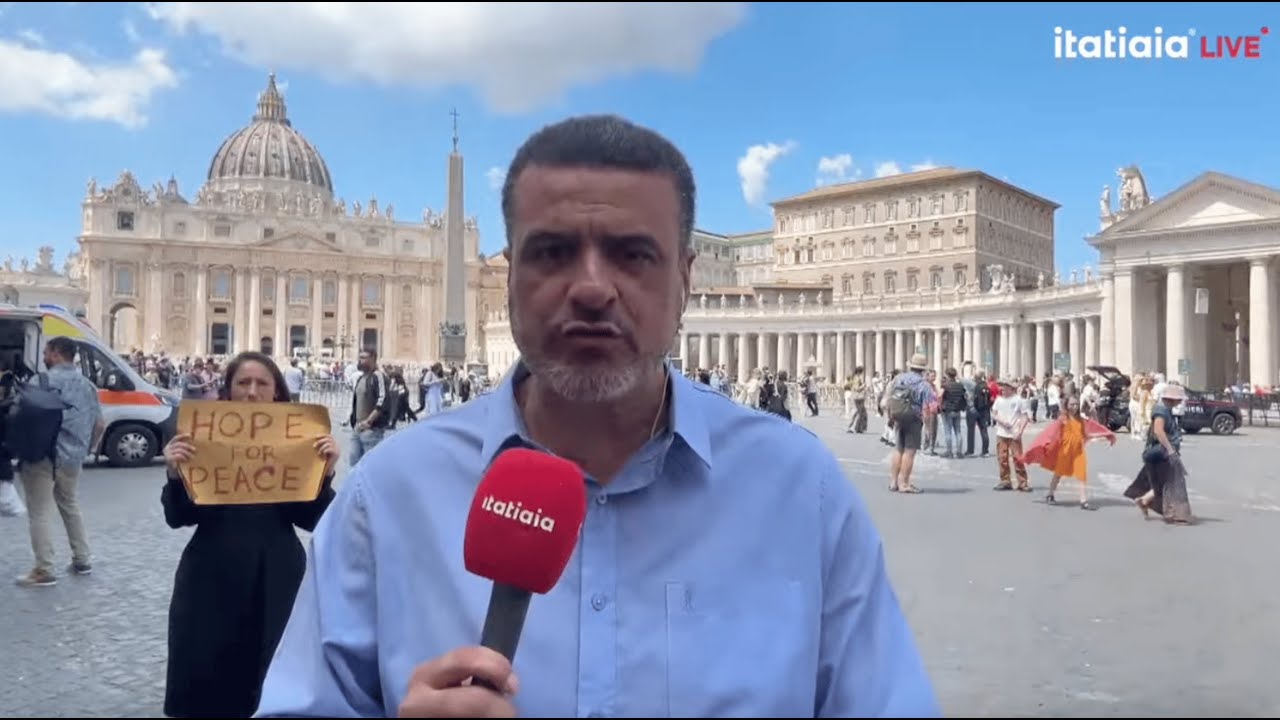 Yona Tukuser holds a "HOPE FOR PEACE" sign in St. Peter's Square at the Vatican during the Conclave