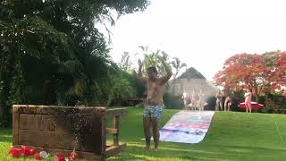 Kid slides down Slip N' Slide and crashes face first into wood table