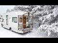 Camping dans le confort de la maison avec un camion caravane dans une neige forte