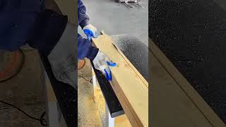 Cutting a thick wooden plank smoothly along a straight guideline using an electric table saw machine