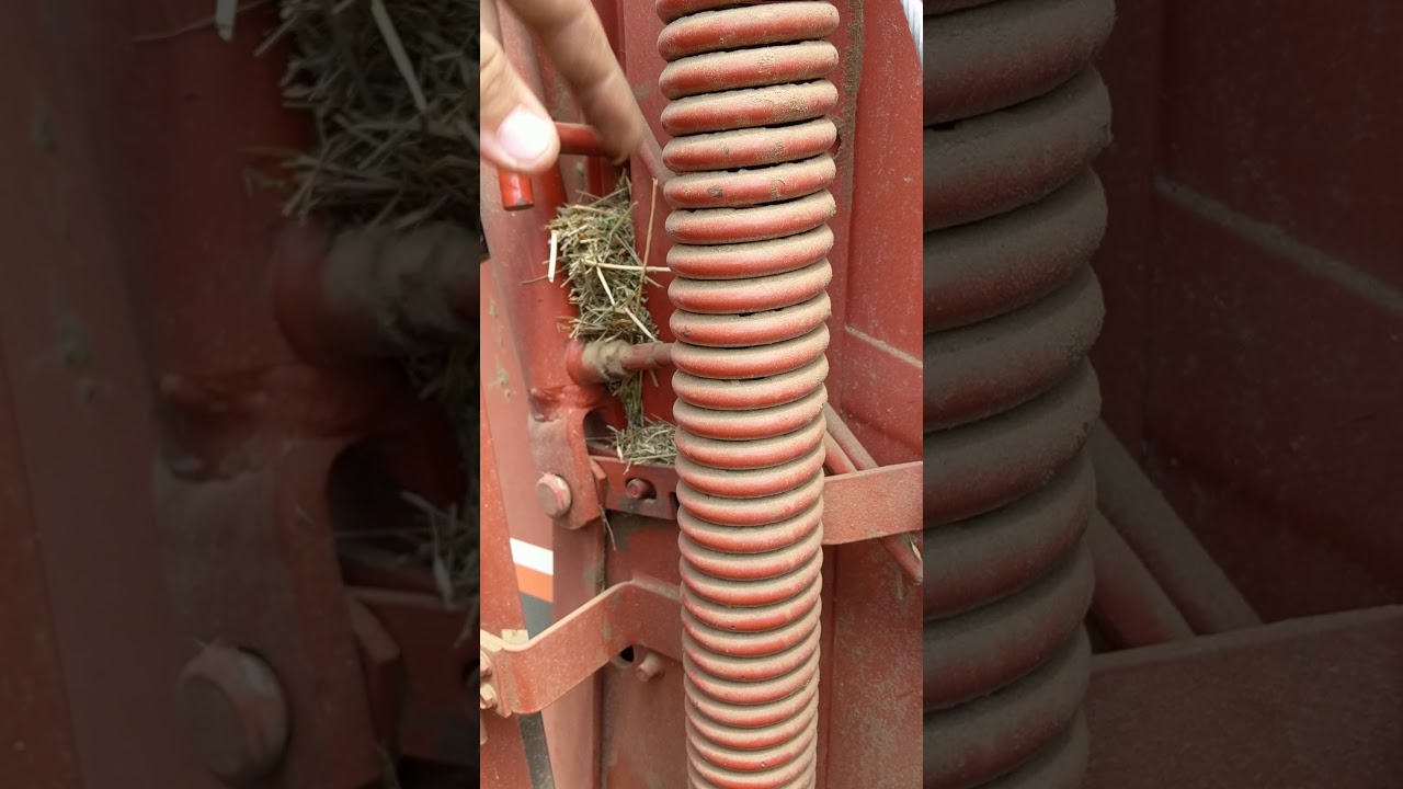 Changing the lower belt tension spring on a Hesston 530 Round Baler