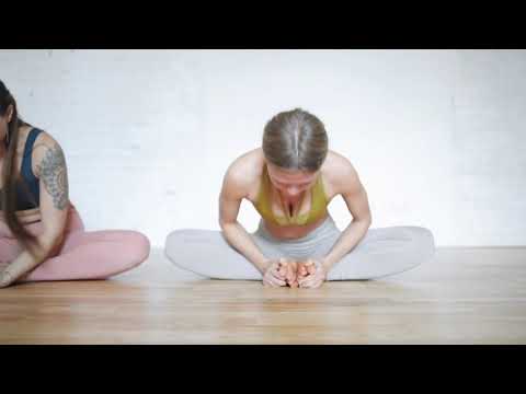 Two Women Performing Yoga Exercises On The Floor