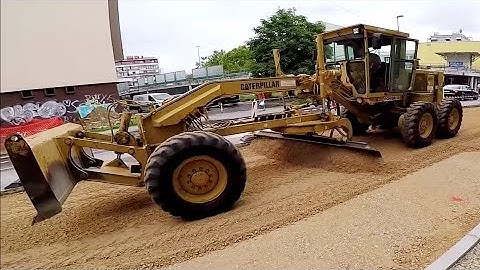 Old Caterpillar Motor Grader Grading In The City-Skilled Operator