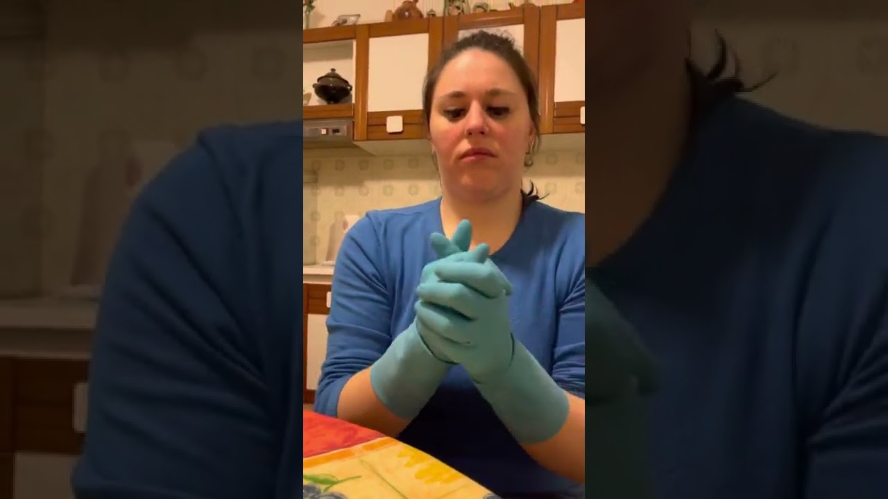 Washing hands with dishwashing liquid in rubber gloves