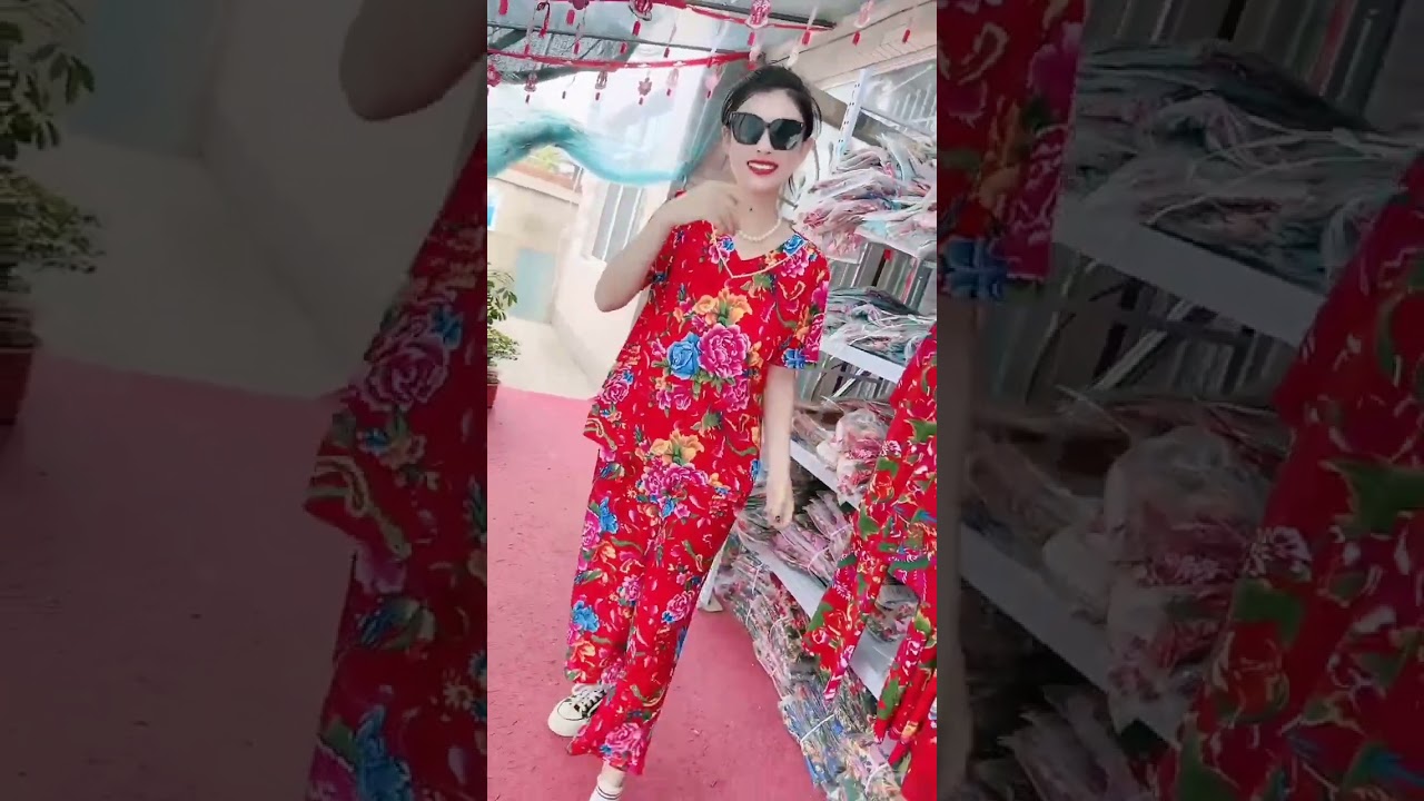 The fabric features a bold floral print in vibrant red, green, pink, and yellow hues, reminiscent of