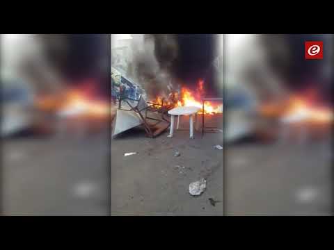 القوى الأمنية أزالت الأكشاك المخالفة في موقف حي السلم وأصحابها يشعلون الاطارات احتجاجا