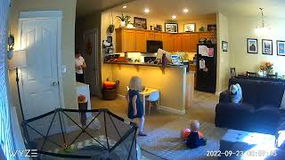 Girl kicks ball in living room that hits little boy on his face and falls back (Security camera)
