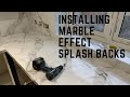 Installing marble effect splash backs.