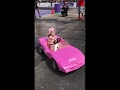 Little girl doing burnouts in toy car