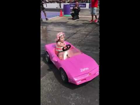 little girl doing burnouts in toy car
