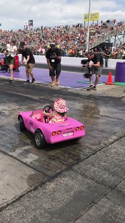 little girl doing burnouts in toy car