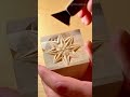 carving a geometric star pattern into a wooden block using a specialized chip carving hand tool