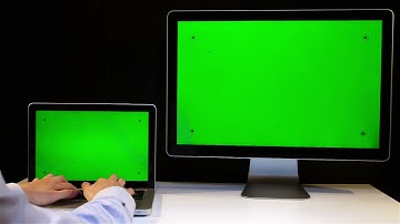 Man working on the laptop and display with a green screen at the workplace - No Copyright