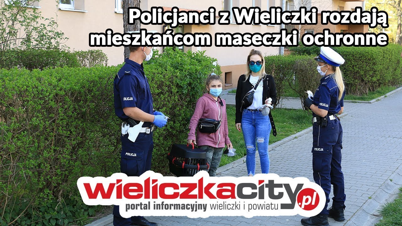 Policjanci z Komendy Powiatowej Policji w Wieliczce rozdają mieszkańcom maseczki ochronne