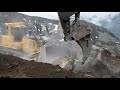 Komatsu D375A-8 and Volvo EC750E extracting rocks