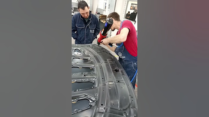 Нанесение шовного кузовного герметика на капот автомобиля опытным специалистом.