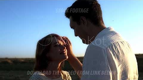 Slow motion of kissing caucasian couple in a summer field