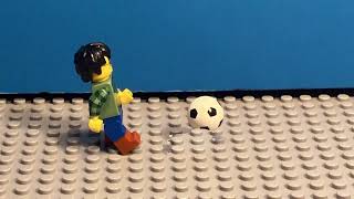 A lego man kicks a football in Lego City.