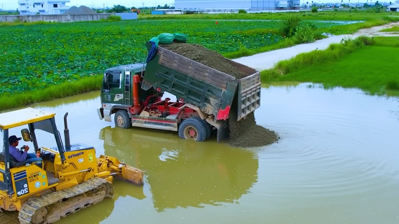 Dump Truck Unloading Soil into Flooded Farmland During Rural Land Reclamation Work