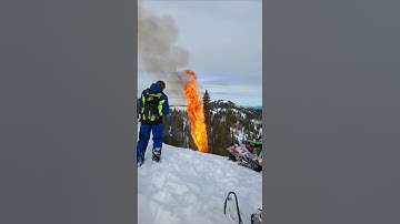 Snowmobiler Parked Close to a Burning Tree