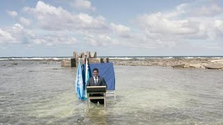Tuvalu minister stands knee deep in seawater to address world leaders