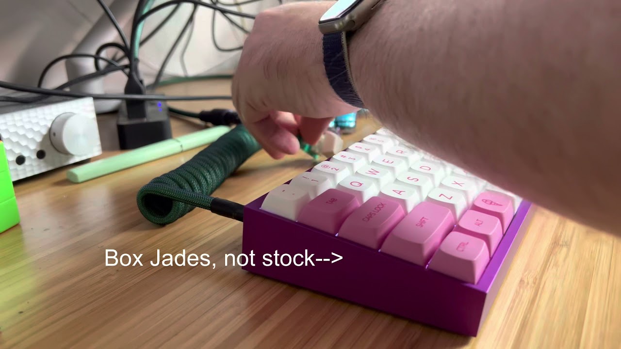 Box Jades in a tofu65 on a messy desk with a Corne cameo