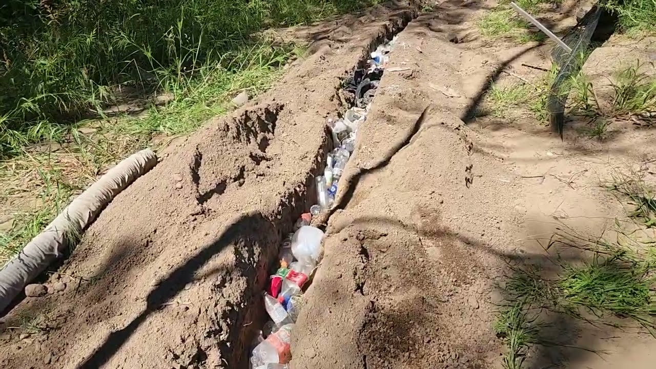 making a French drain using plastic bottles in replacement for river rock!