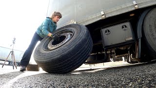 A day in the life of a female truck driver changing a flat tire