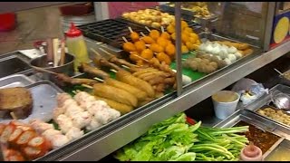 Hong kong street food at causeway bay. this popular snack shop serves
an array of hot snacks such as fish balls, sui mai, octopus legs,
offal and soup skewer...