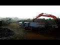 Alat berat Excavator dump truk bekerja keras mengangkut muatan di tengah cuaca ekstrem