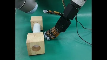 Exploiting environmental constraints by a robotic hand with soft materials and rigid structures