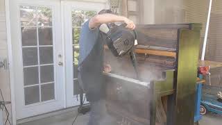 Blowing the dust out of an old upright piano