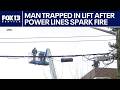Man trapped in lift after power lines spark fire in Seattle