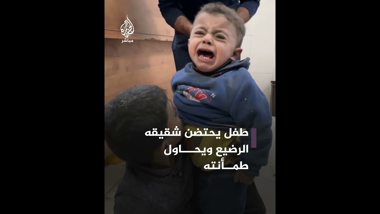 غزة.. طفل فلسطيني يحتضن أخيه الرضيع ويحاول طمأنته عقب نجاتهما من قصف إسرائيلي